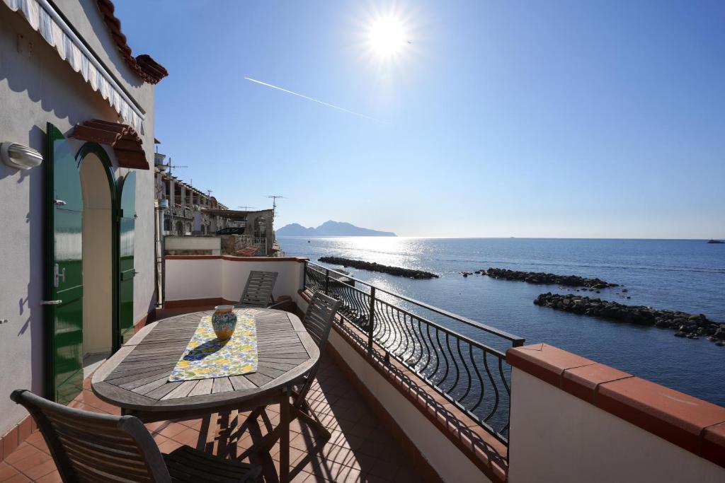 a balcony with a table and chairs and the ocean at House Dream on the sea in Massa Lubrense
