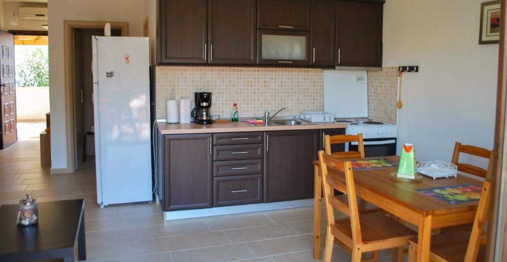 a kitchen with a table and a kitchen with a refrigerator at Canal Luxury Apartments in Nea Potidaea