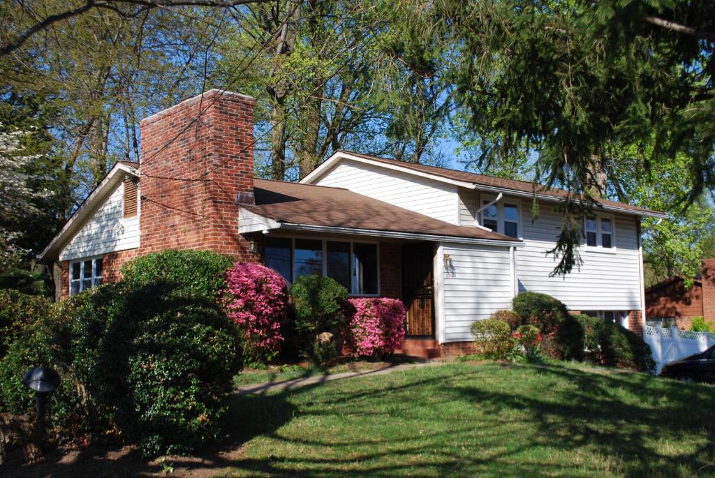 a white house with a brick chimney on a yard at Cozy Bedroom Convenient Location in Bethesda