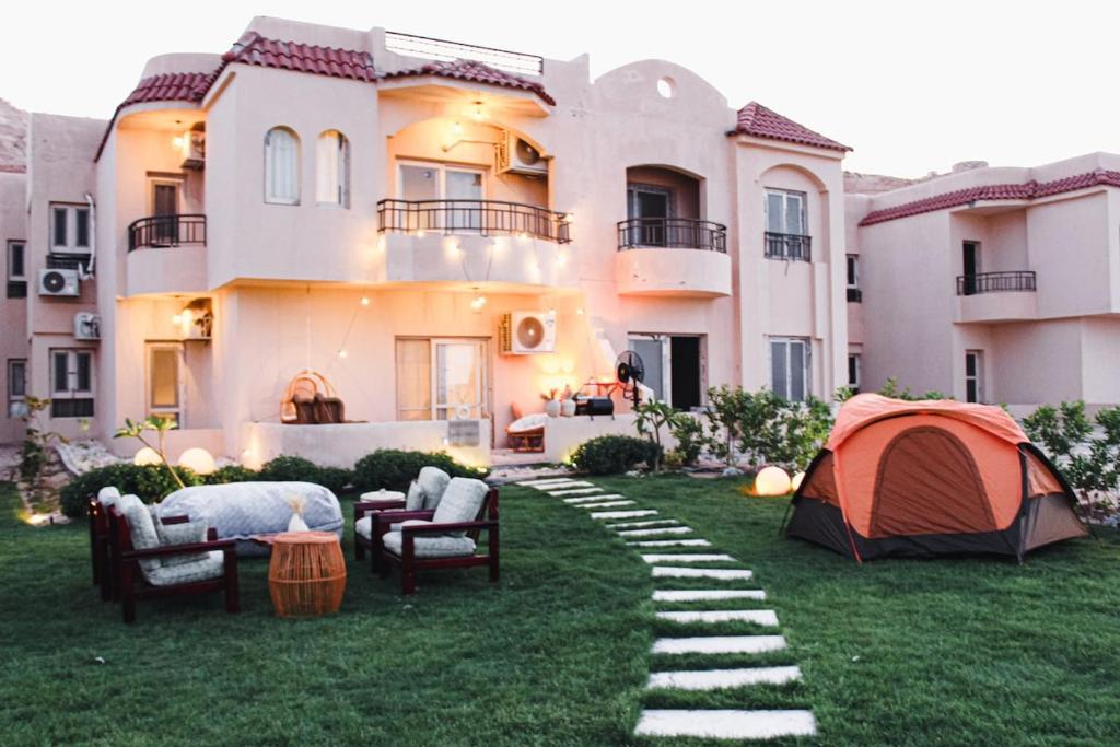 a house with a tent in the yard at Coral Hills 2nd Row Chalet with Panoramic Sea View in Alexandria