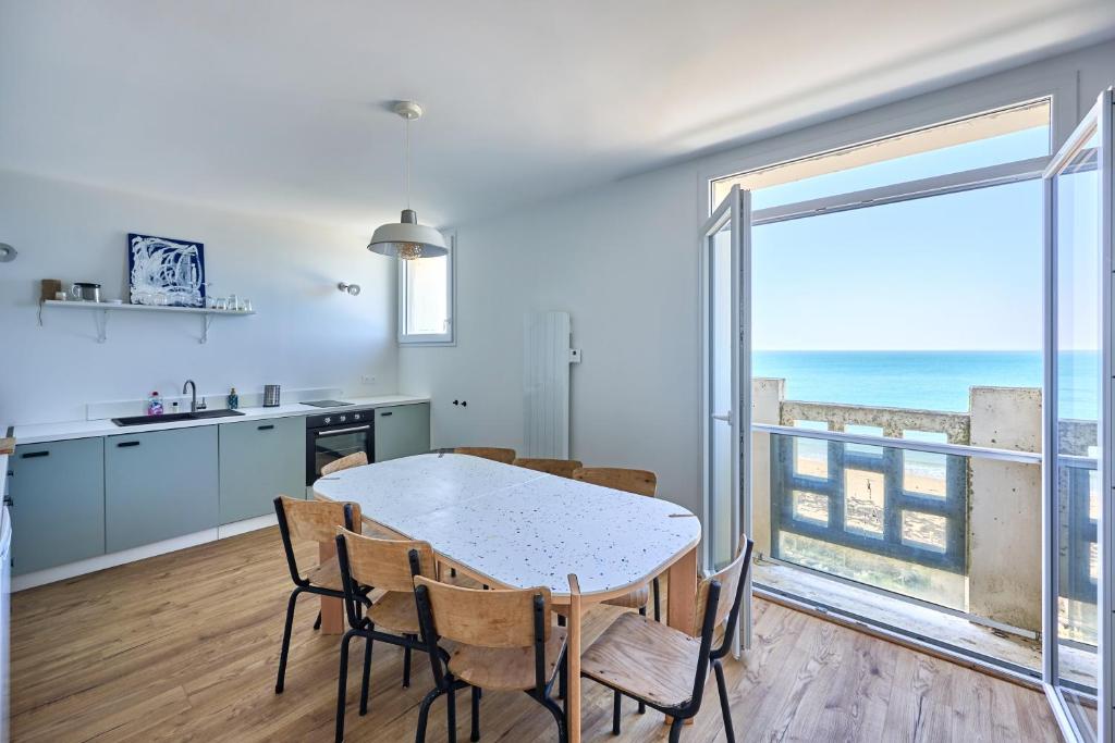 une cuisine et une salle à manger avec une table et des chaises dans l'établissement Le Nid Maritime - duplex proche de la plage, à Barneville-Carteret