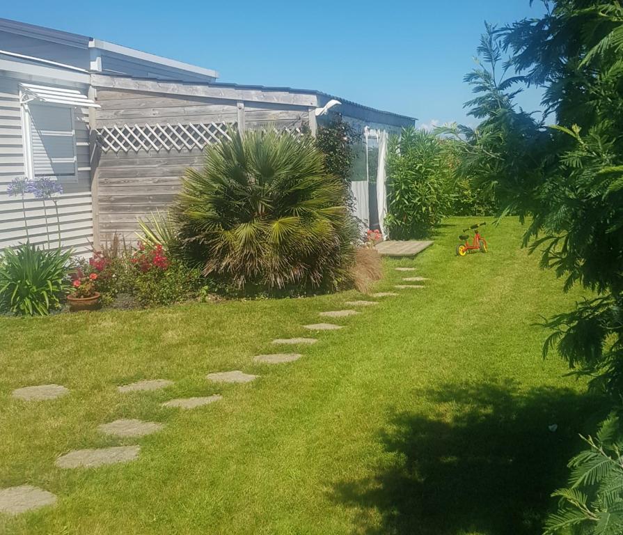 une arrière-cour avec une pelouse et des escaliers dans l'établissement Mobilhome sur terrain privé, à La Celle-sous-Gouzon