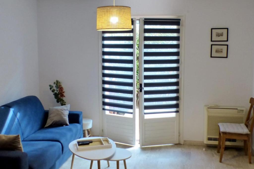 un salon avec un canapé bleu et une table dans l'établissement Apartment of 36 m2 with terrace Sanary-sur-Mer, à Sanary-sur-Mer