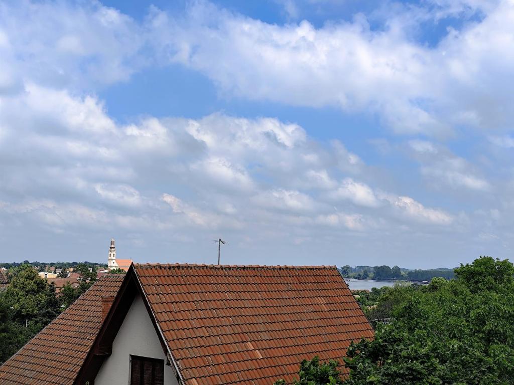 una casa con un tetto rosso con un cielo di Apartment Sandra a Stari Banovci