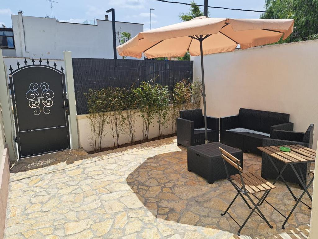 een terras met parasol, meubilair en hek bij La Casa del Borgo in Lecce