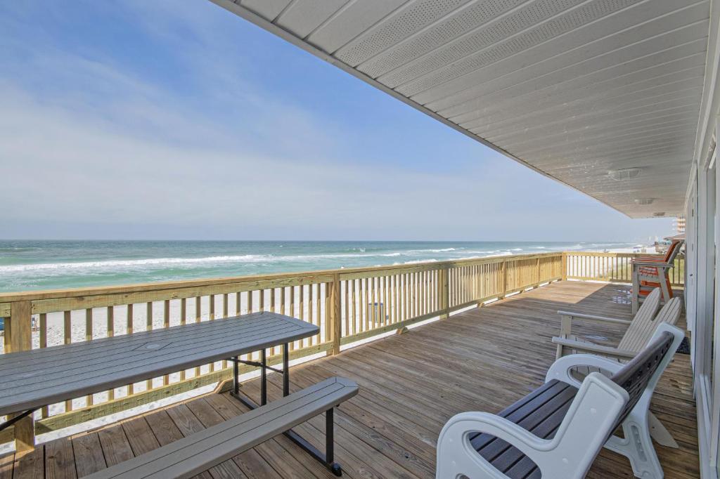 a porch with two benches and a table and the ocean at Island Time- Wonderful Private Beachfront Home - Beautiful!!! in Panama City Beach