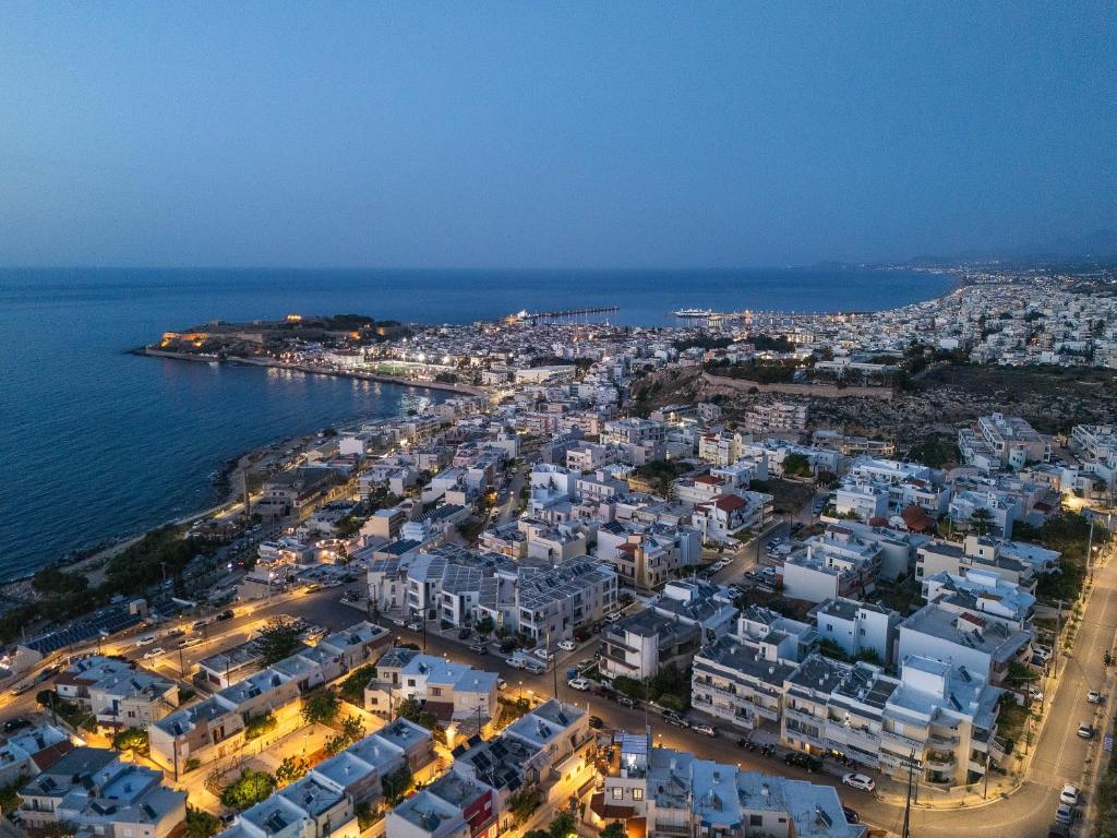 Amaltheia Luxury Residence في مدينة ريثيمنو: اطلالة جوية على مدينة بجوار المحيط