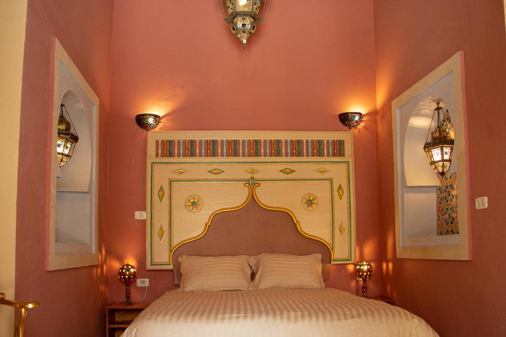 a bedroom with a large bed with a white bedspread at Dar Shams Riad Medina de Sousse in Sousse