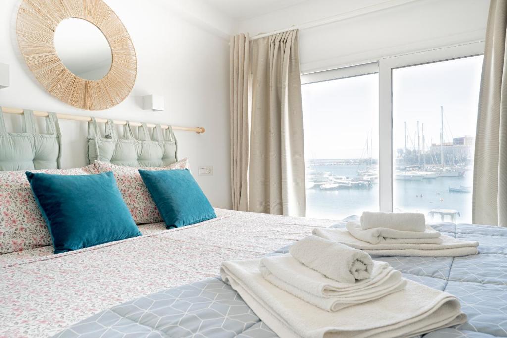 a bedroom with a large bed with towels on it at Eos Sea View Apartments in Syracuse