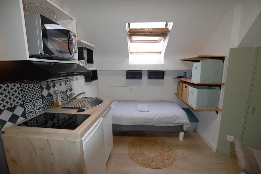- une petite cuisine avec un lit dans une petite pièce dans l'établissement Studio gare Viotte et centre ville, à Besançon