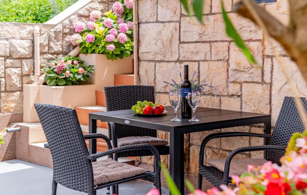 a table and chairs on a patio with flowers at Apartman Jagoda - Vela Luka by Villas Guide in Vela Luka