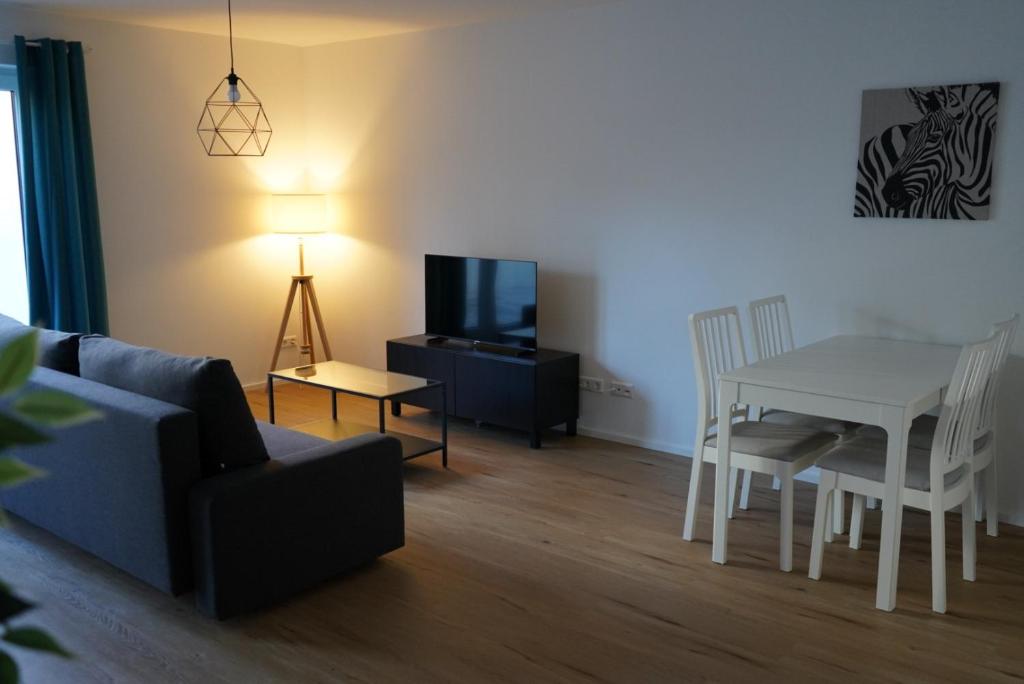 a living room with a couch and a table and a television at Ferienwohnungen Rosengarten in Mommenheim