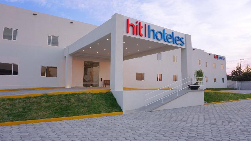 un bâtiment avec un panneau sur son côté dans l'établissement Hit Hoteles Aeropuerto Puebla, à Huejotzingo