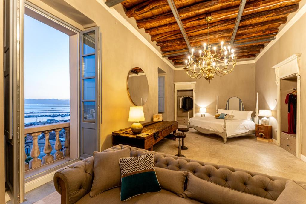 a living room with a couch and a bed and a window at Saint Amand by Palazzo Boyl in Cagliari