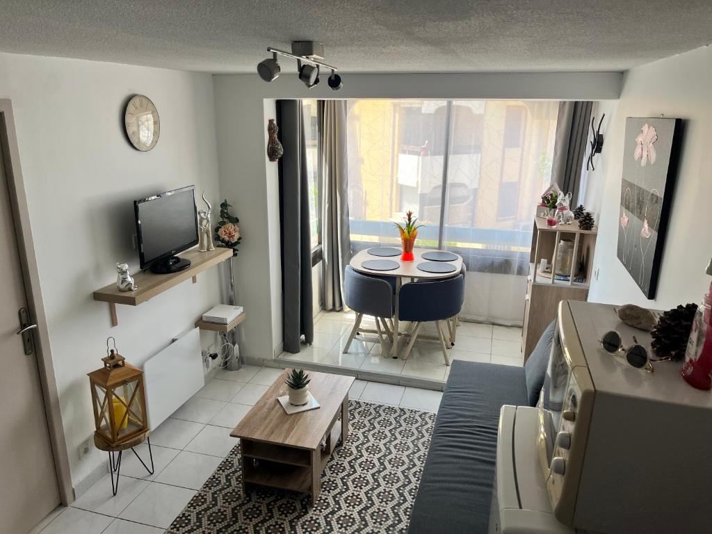 un salon avec un canapé et une table dans l'établissement appartement 2 étoile à moins de 100m de la plage vu sur Le Canigó, à Saint Cyprien Plage