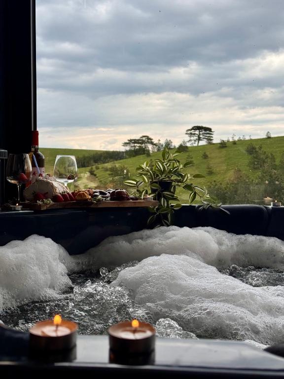 una vasca da bagno piena d'acqua con tre candele di Zlatibor Wild nest Rabbit Lux a Zlatibor