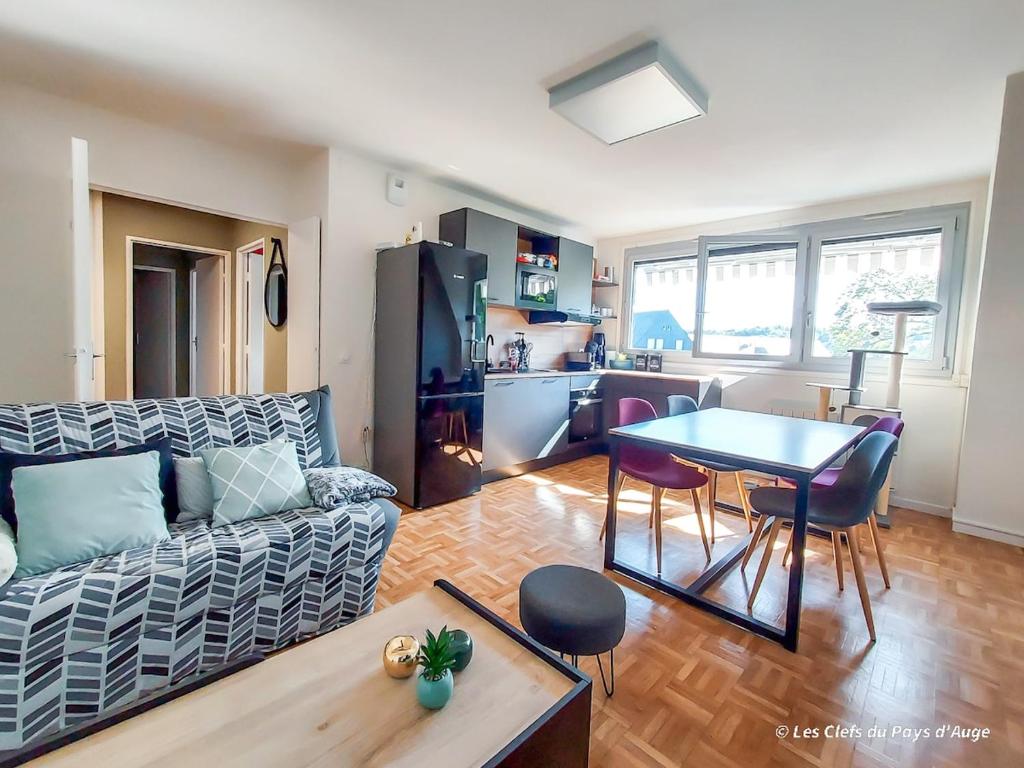 un salon avec un canapé et une table dans l'établissement Bel appartement, 2 chambres, proche gare et centre ville, tout à pied, à Lisieux