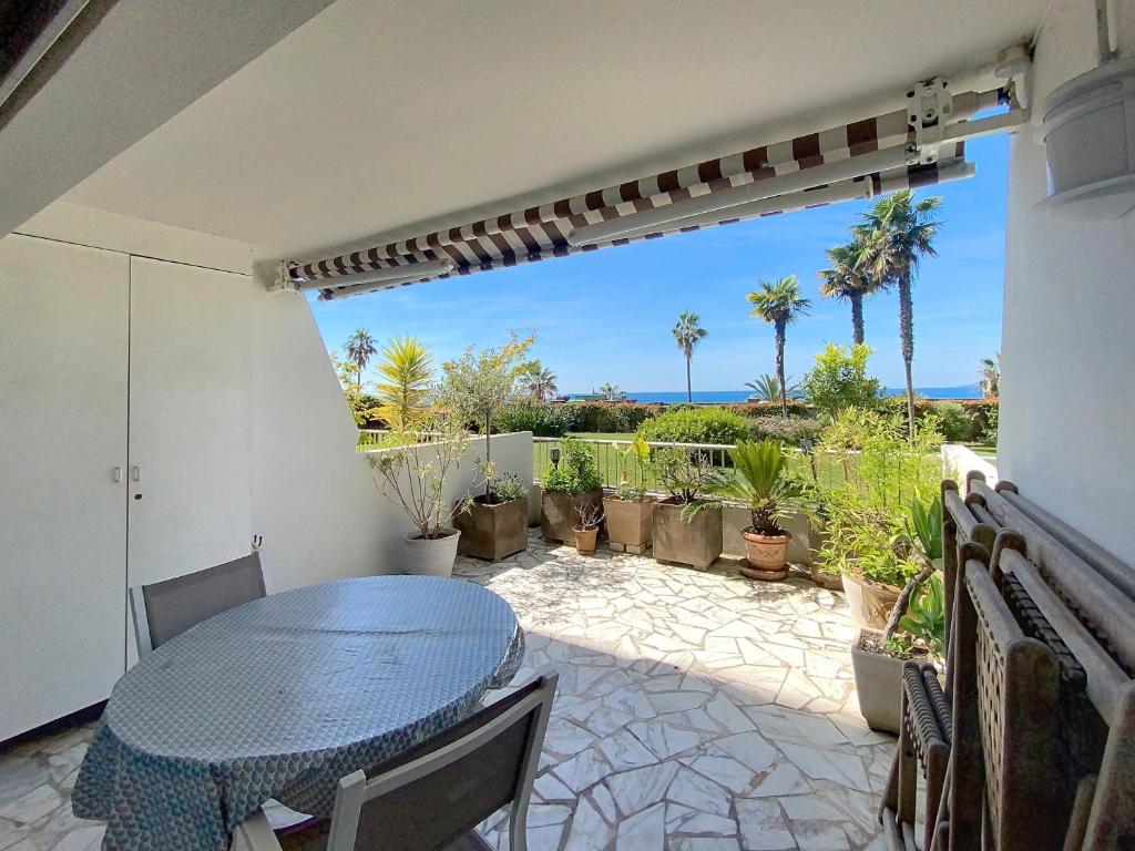d'une terrasse avec une table, des chaises et des palmiers. dans l'établissement Superbes prestations grande terrasse 352L, à Cannes