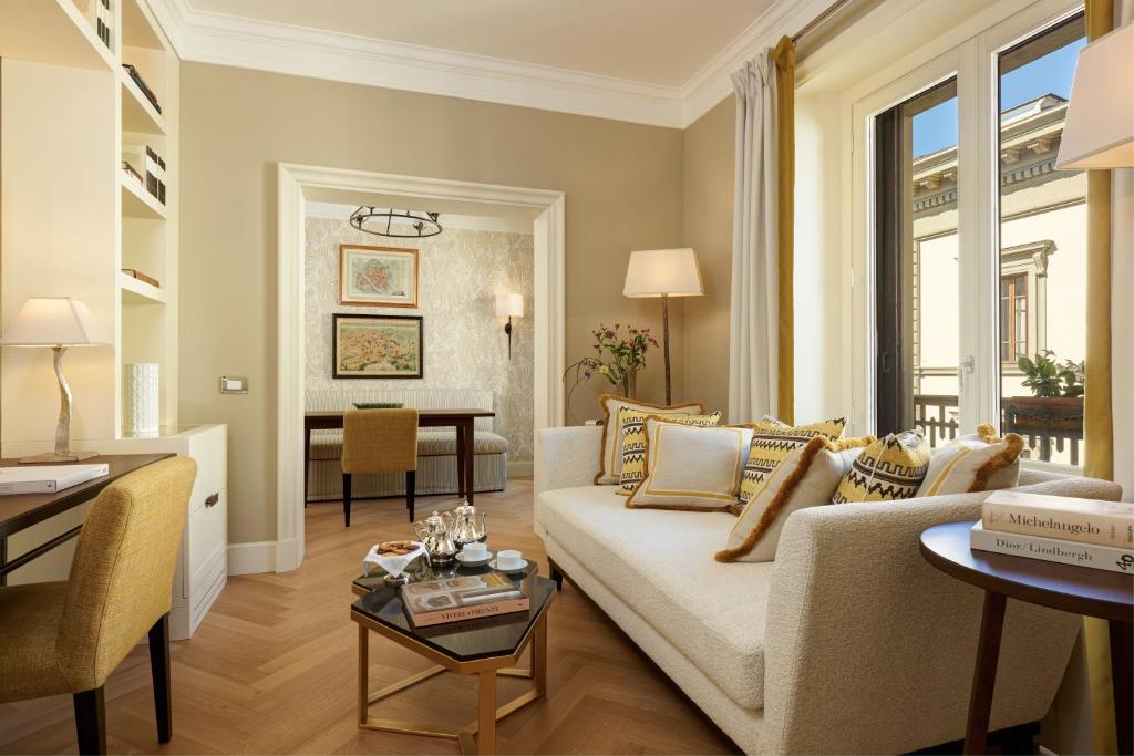a living room with a couch and a table at Rocco Forte Hotel Savoy in Florence