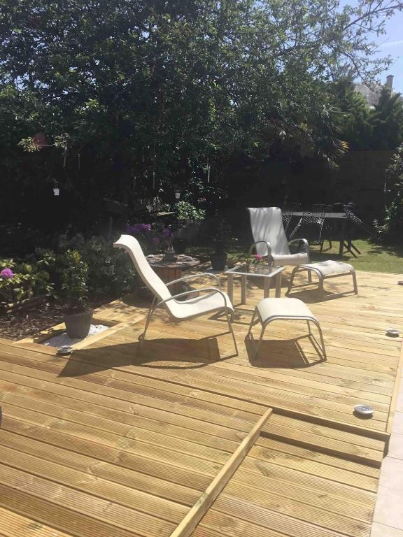 deux chaises et une table sur une terrasse en bois dans l'établissement Studio à 50M de la mer avec SPA, à Grandcamp-Maisy