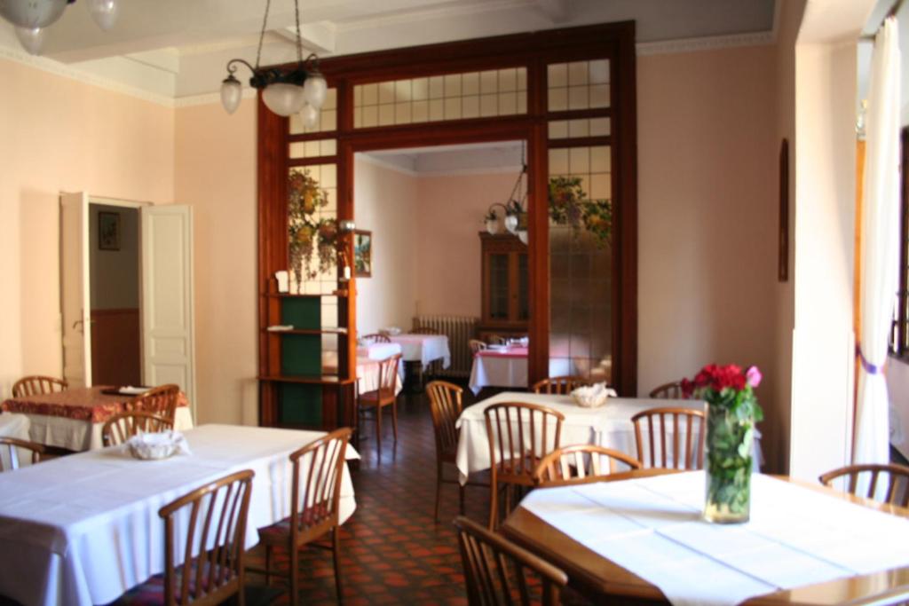 un restaurante con mesas y sillas con manteles blancos en Hotel Al Sogno, en Alassio