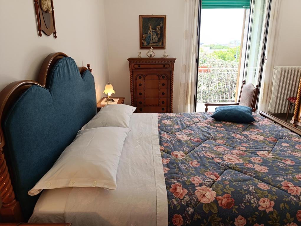 a bedroom with a bed with a quilt and a window at Le Rondini in Trani