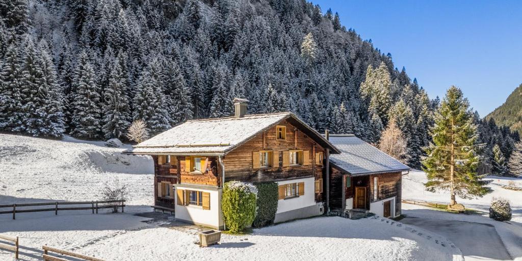 a wooden house in the snow with a mountain at Casa Romantica - ein Alpiner Traum in Partenen