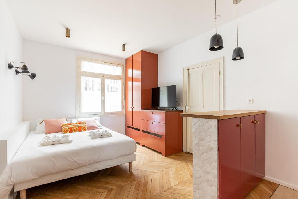 - une chambre avec un lit, une télévision et une cheminée dans l'établissement Nicolo Passy Magnifique Studio, à Paris