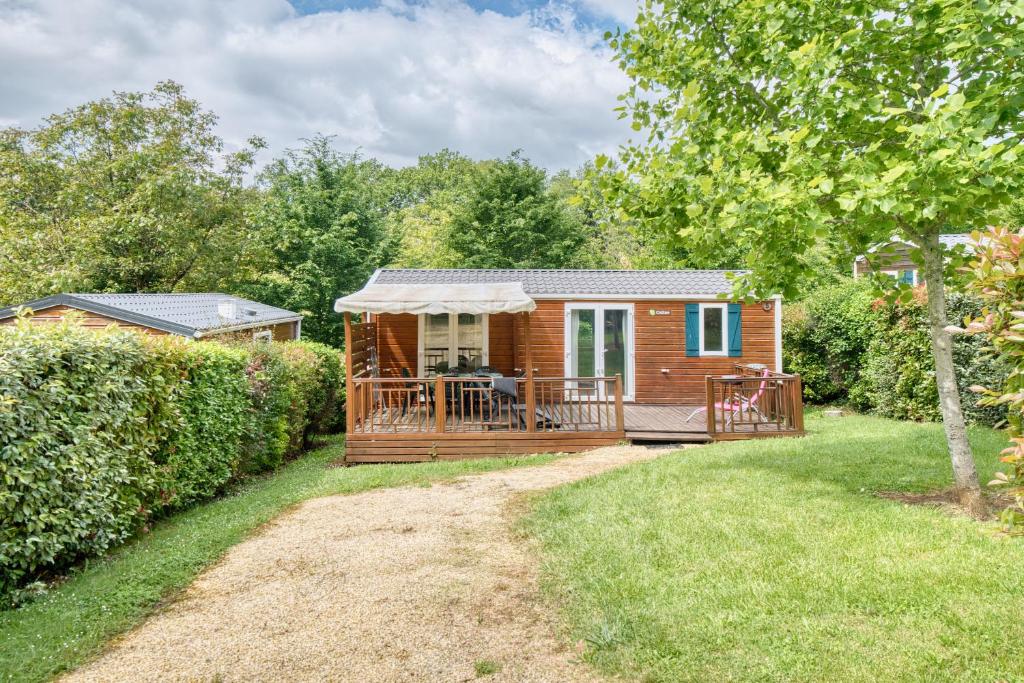 une cabane en rondins avec une véranda et une terrasse dans l'établissement Le Mobilhome du Perigord Vert, à Saint-Chamassy