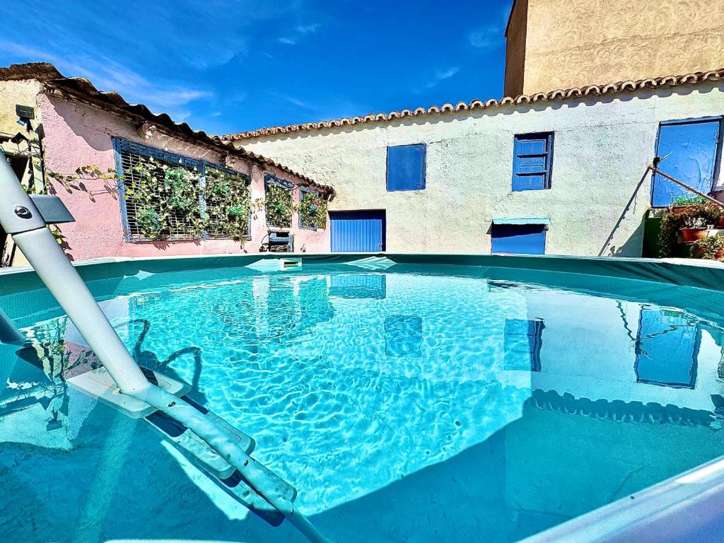 a large swimming pool in front of a building at Casa Rural al Sol De Las Ruinas- piscina privada in Belchite