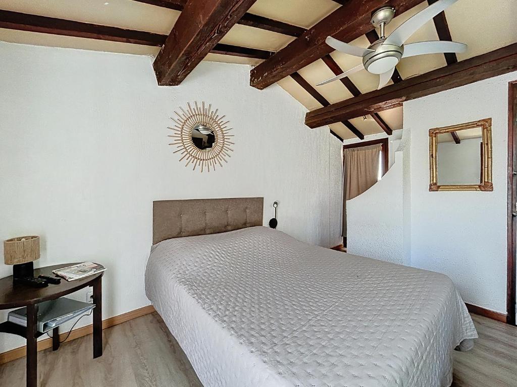 une chambre avec un lit et un ventilateur de plafond dans l'établissement Mas des Colverts, à Saintes-Maries-de-la-Mer
