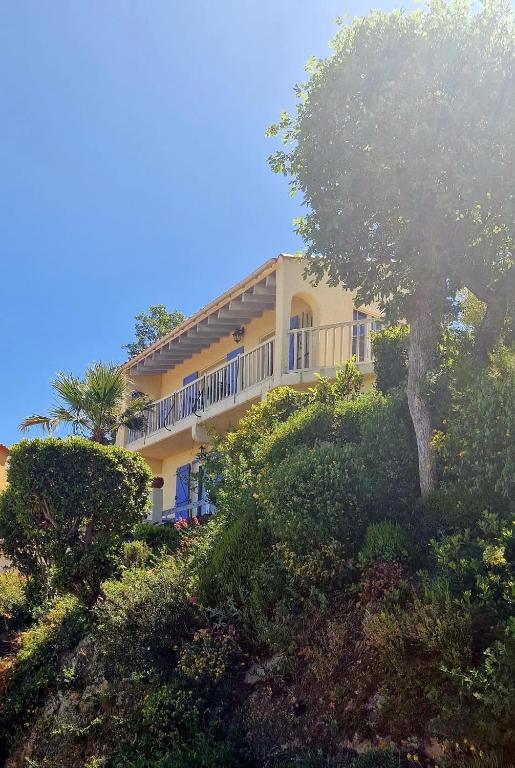 une grande maison jaune sur une colline avec des arbres et des buissons dans l'établissement Belle maison Lila Jade avec superbe vue à 180 degrés piscine partagée, à Laroque-des-Albères