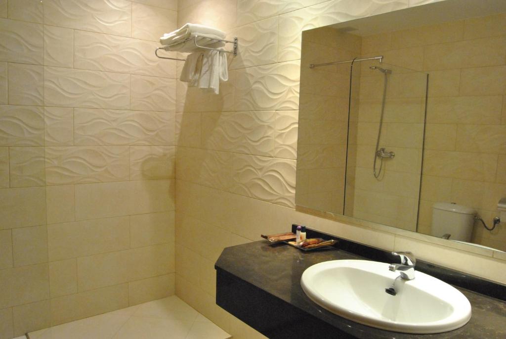 W łazience znajduje się umywalka i lustro. w obiekcie Motel Cancun Oviedo w mieście Llanera