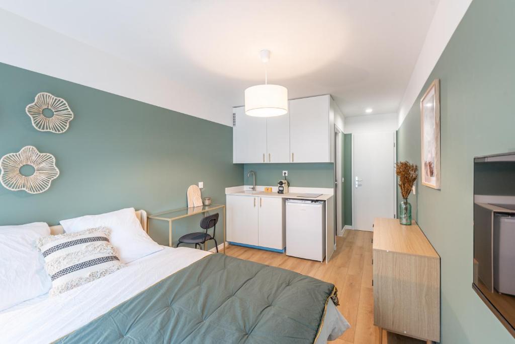 Il comprend une chambre avec un lit et une cuisine avec un évier. dans l'établissement M110 Marquer Joli Studio proche du centre et de la gare, à Annemasse