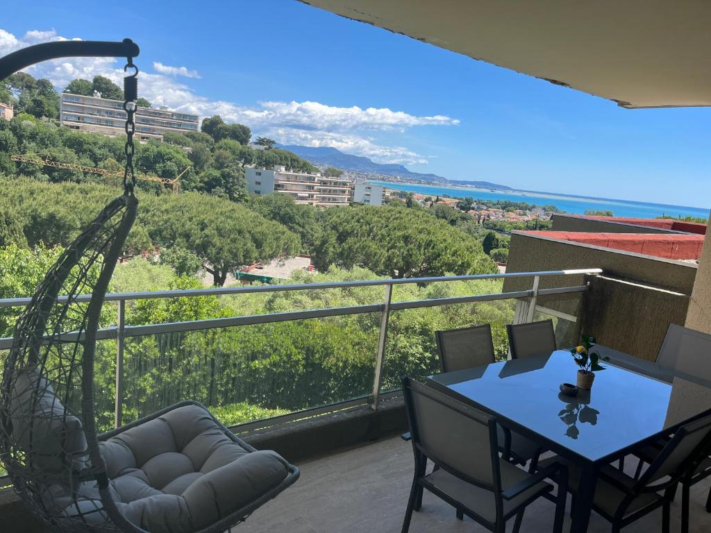 a balcony with a table and chairs and a view at Appartement vu mer et montagnes in Villeneuve-Loubet