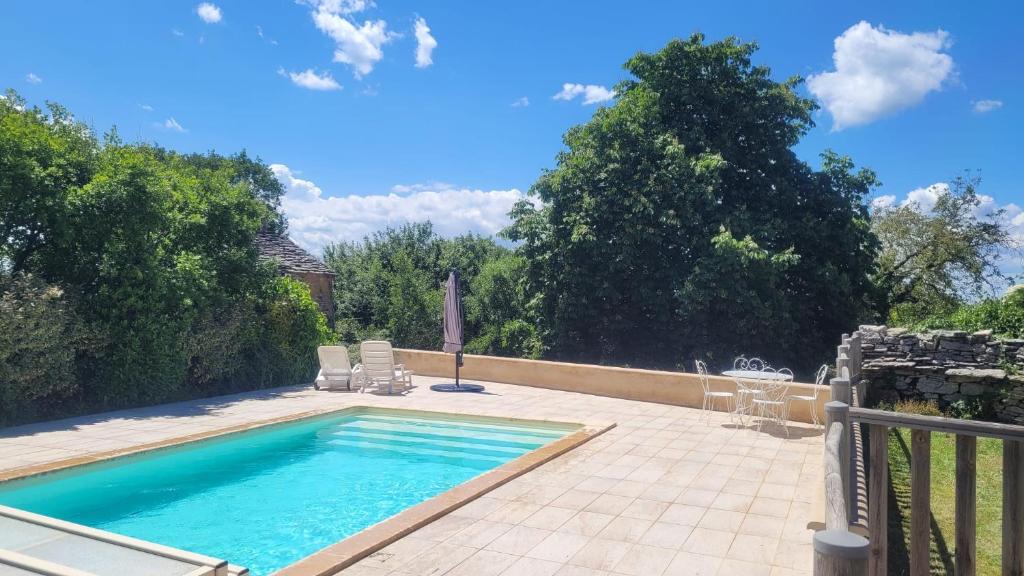 - une piscine sur une terrasse avec des chaises et une clôture dans l'établissement Charmant gîte en pierres, à Saint-Jean-de Laurs