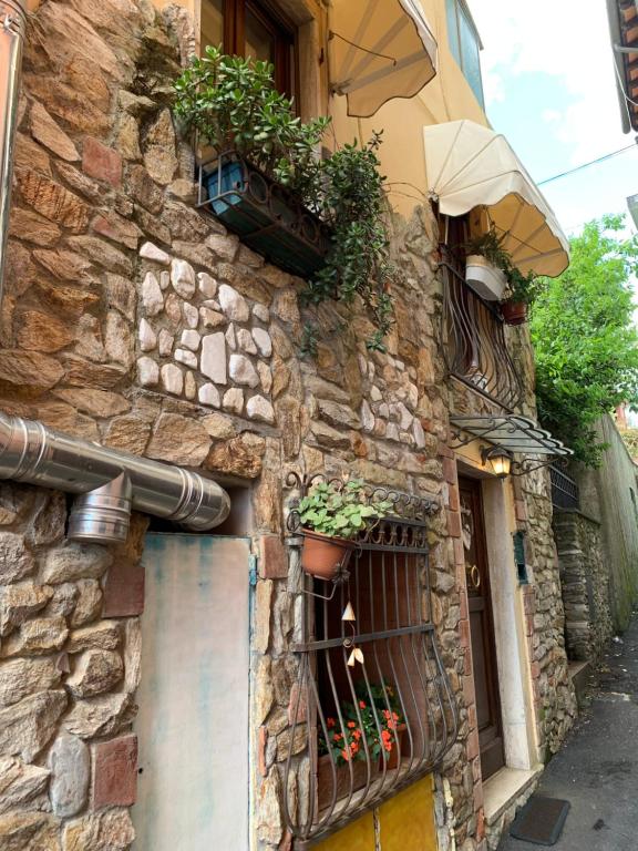 a stone building with potted plants on the side of it at Vicolo Castellaccio in Massa