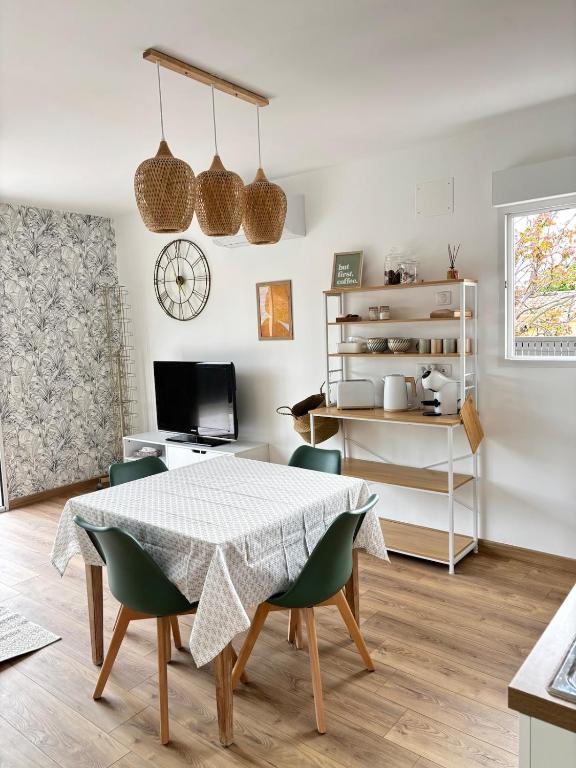 une salle à manger avec une table et des chaises vertes dans l'établissement La p'tite maison, à Forcalquier