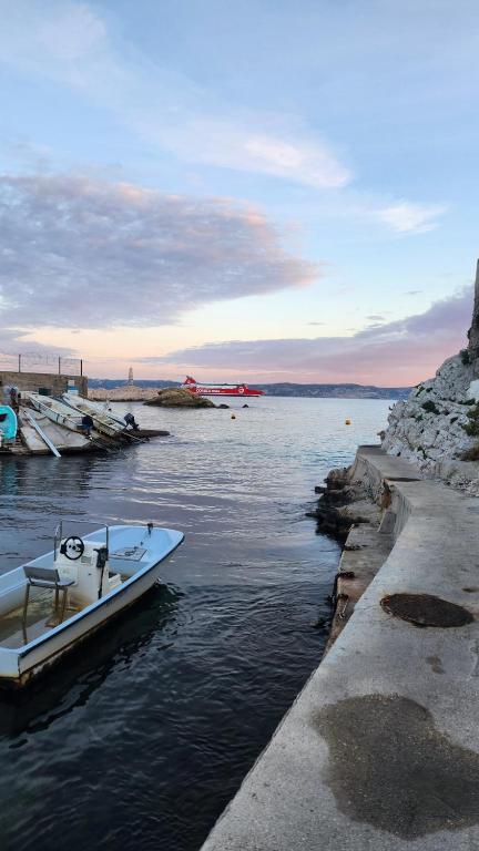 un petit bateau est amarré dans un corps d'eau dans l'établissement Malmousque Family House, à Marseille