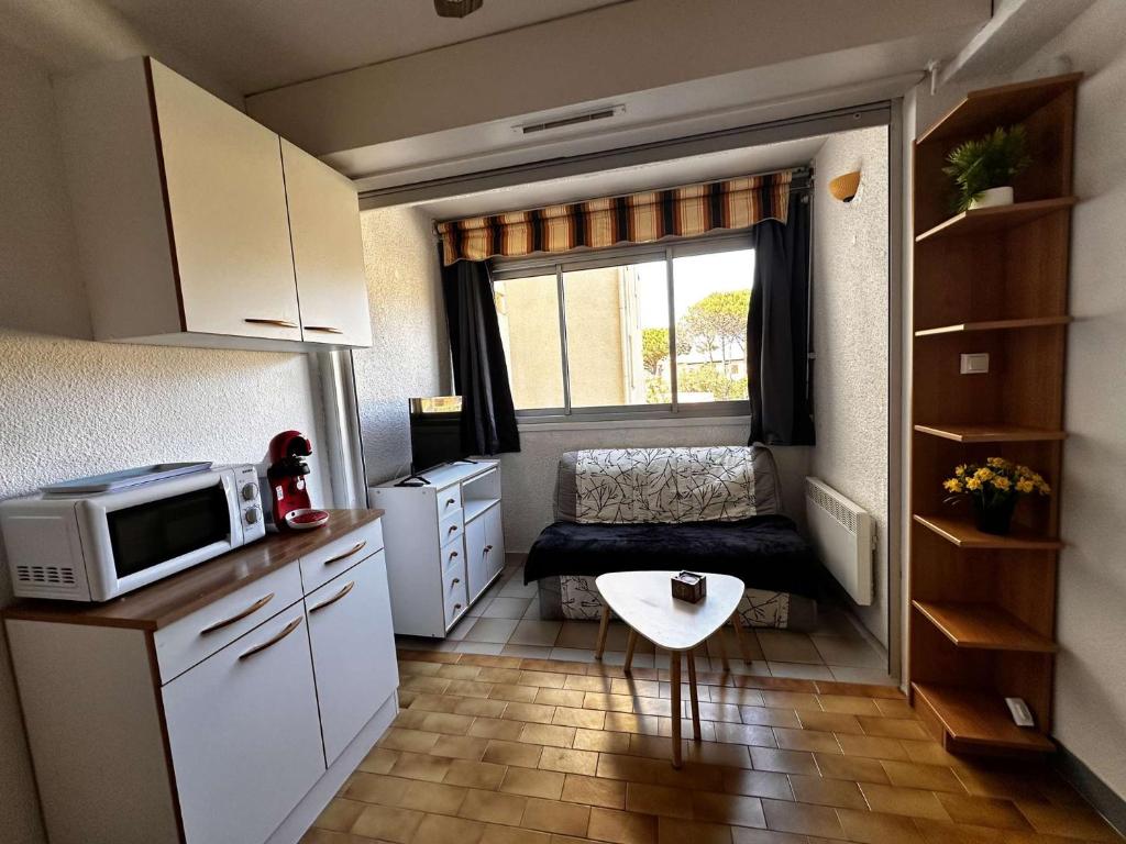 une petite cuisine avec un four micro-ondes et une fenêtre dans l'établissement NP200-89-11 2 pièces, Narbonne Plage, à Narbonne-Plage