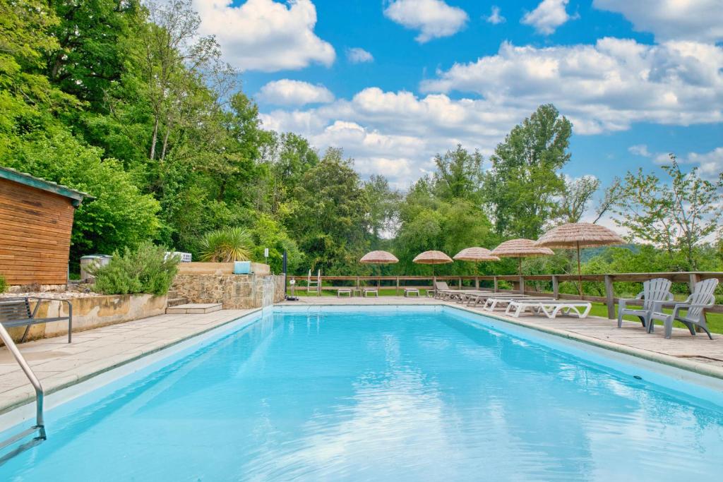 une grande piscine avec chaises et parasols dans l'établissement Gite Welcome, à Campagne