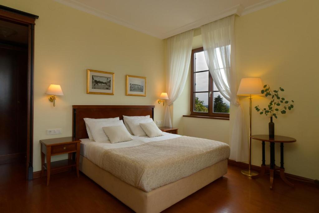 a bedroom with a bed with two lamps and a window at Dvorec Jeruzalem in Ivanjkovci