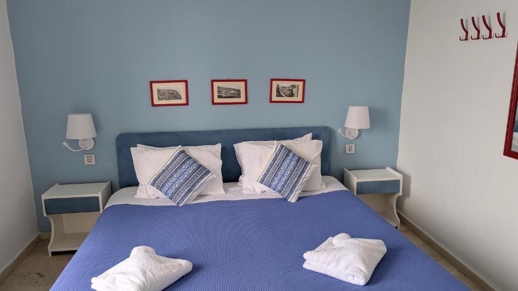a blue bedroom with a bed with two pillows at Coral in Frangokastello
