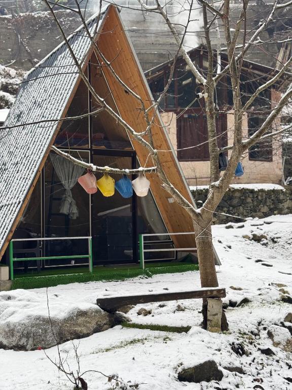 a building with a clothes line in the snow at Sunshine Cafe & Cottage Riverside in Shoja