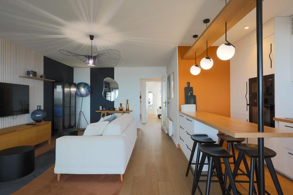 a living room with a white couch and a table at Superbe appartement haut de gamme 4 personnes en Front de mer in Plérin