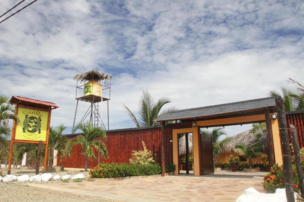 un edificio con una torre de reloj encima en Guille Bungalows en Canoas De Punta Sal