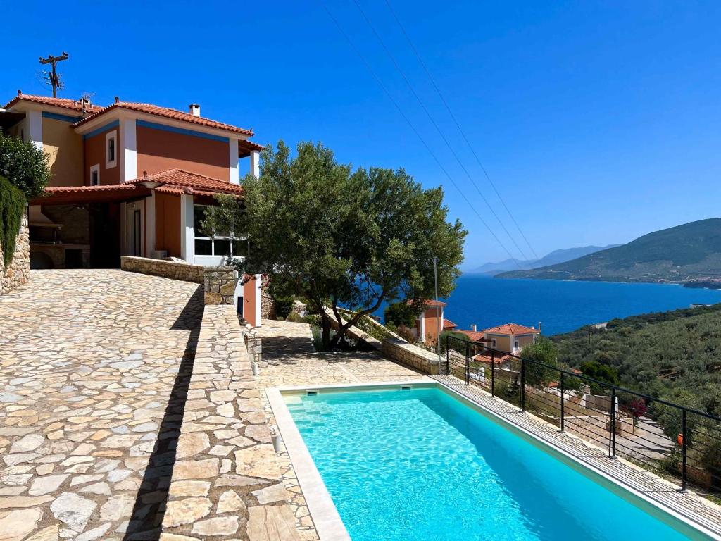 a villa with a swimming pool and a view of the water at Villa Galini in Astros
