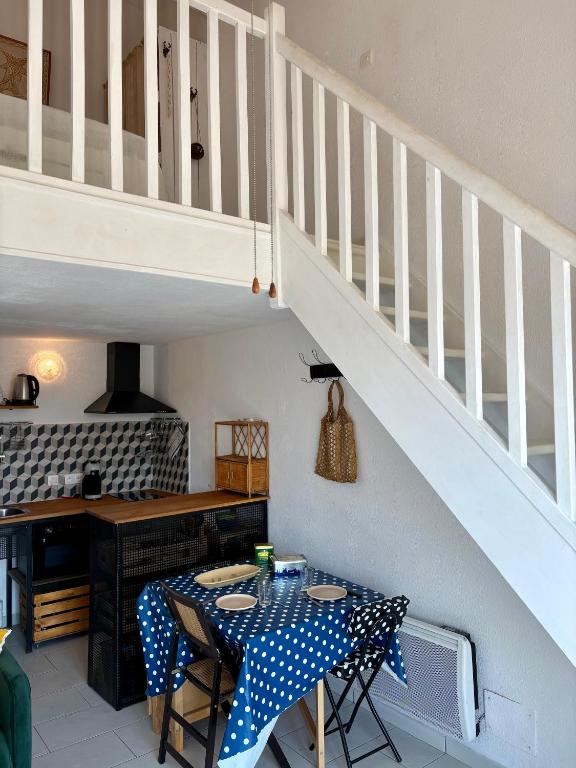 une salle à manger avec une table et un escalier dans l'établissement Superbe studio à proximité plage te commerce 2GOEL27, au Barcarès
