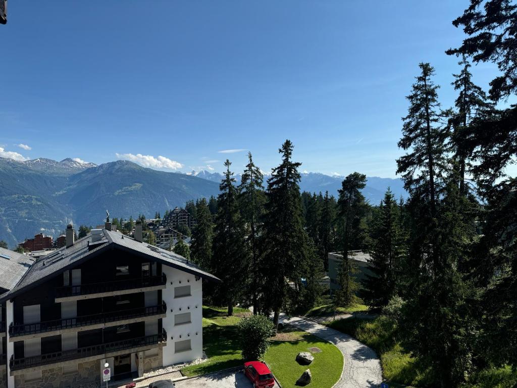 a view of a building with mountains in the background at Mandarin B10 in Crans-Montana