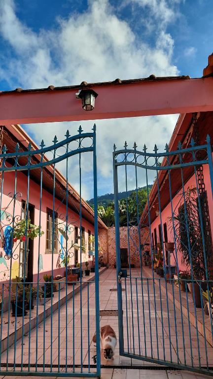 a gate in front of a pink building at Vila Paolino in São Pedro da Serra